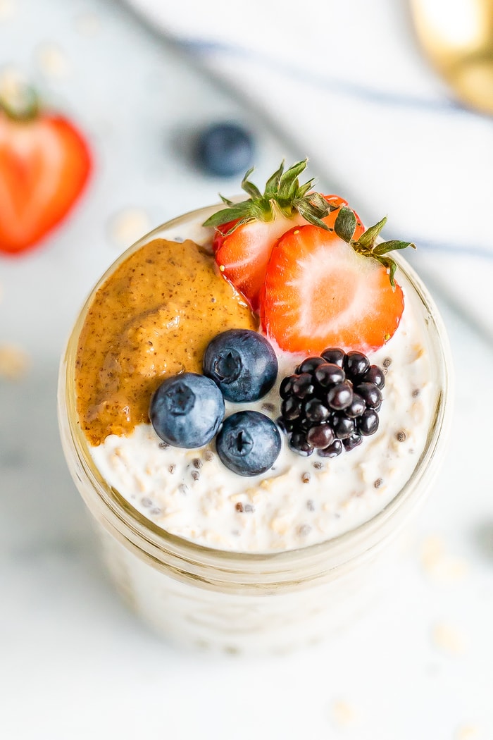 Overhead shot of basic overnight oats with berries and peanut butter on top.