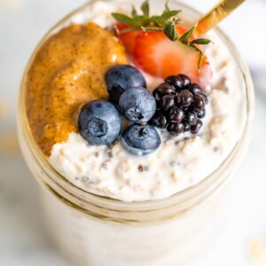 Overhead shot of easy overnight oats with berries and peanut butter on top.