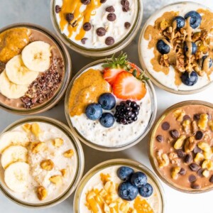 Overhead shot with 7 jars of overnight oats, each with different toppings.
