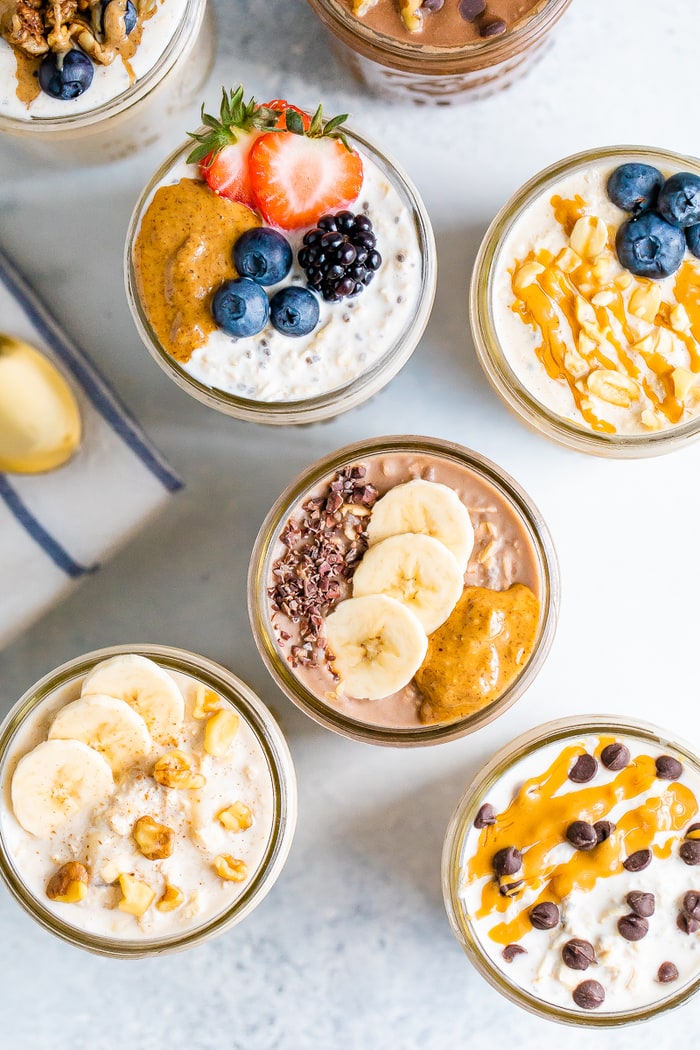 Overhead shot with 7 jars of overnight oats, each with different toppings.