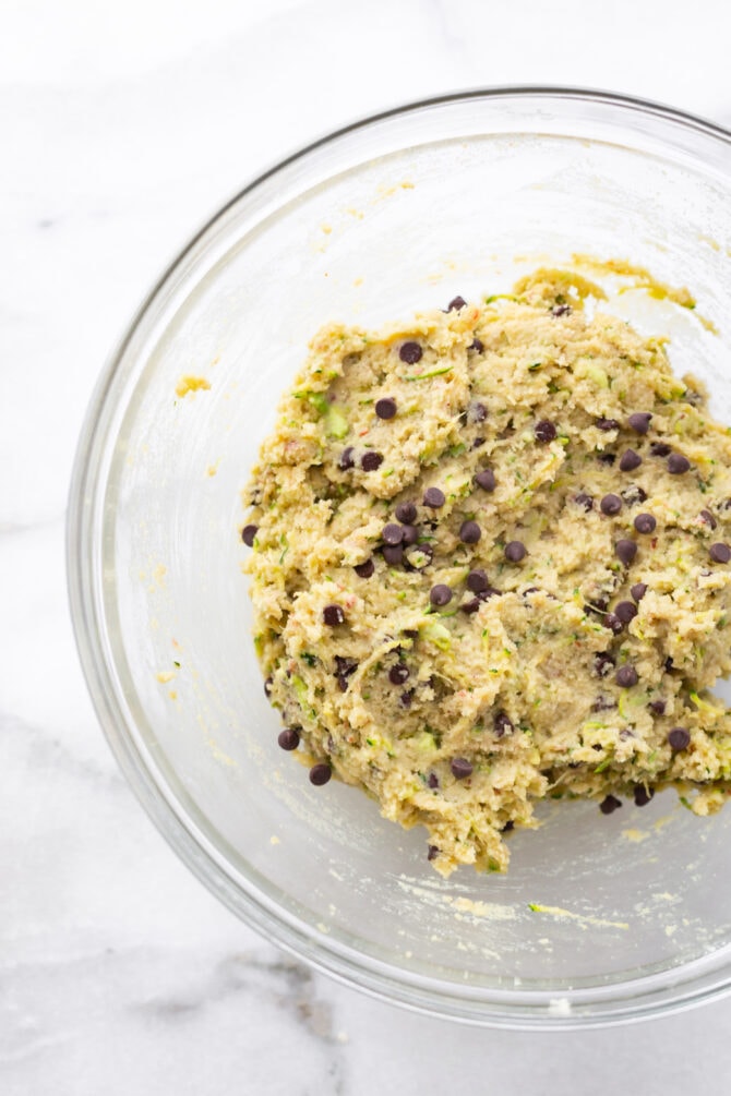 Glass mixing bowl with zucchini bread batter.