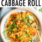 Overhead shot of unstuffed cabbage roll bowl. Cabbage and turkey are mixed with a tomato sauce are served over rice in a white ceramic bowl. Gold fork is resting inside the bowl.