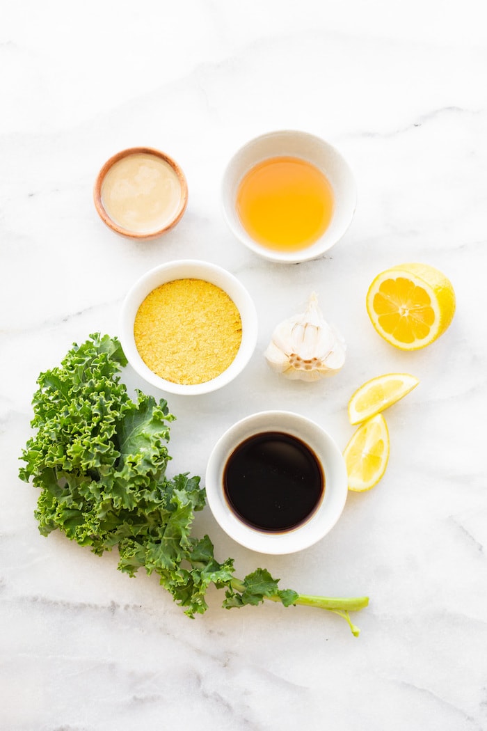 Ingredients for garlicky kale salad on a marble counter.