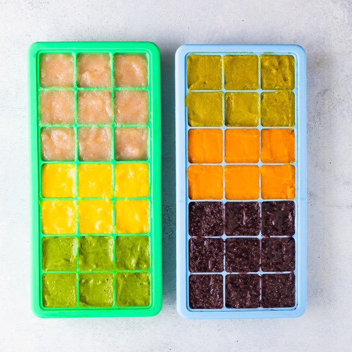 2 silicone ice cube trays with homemade colorful baby food.