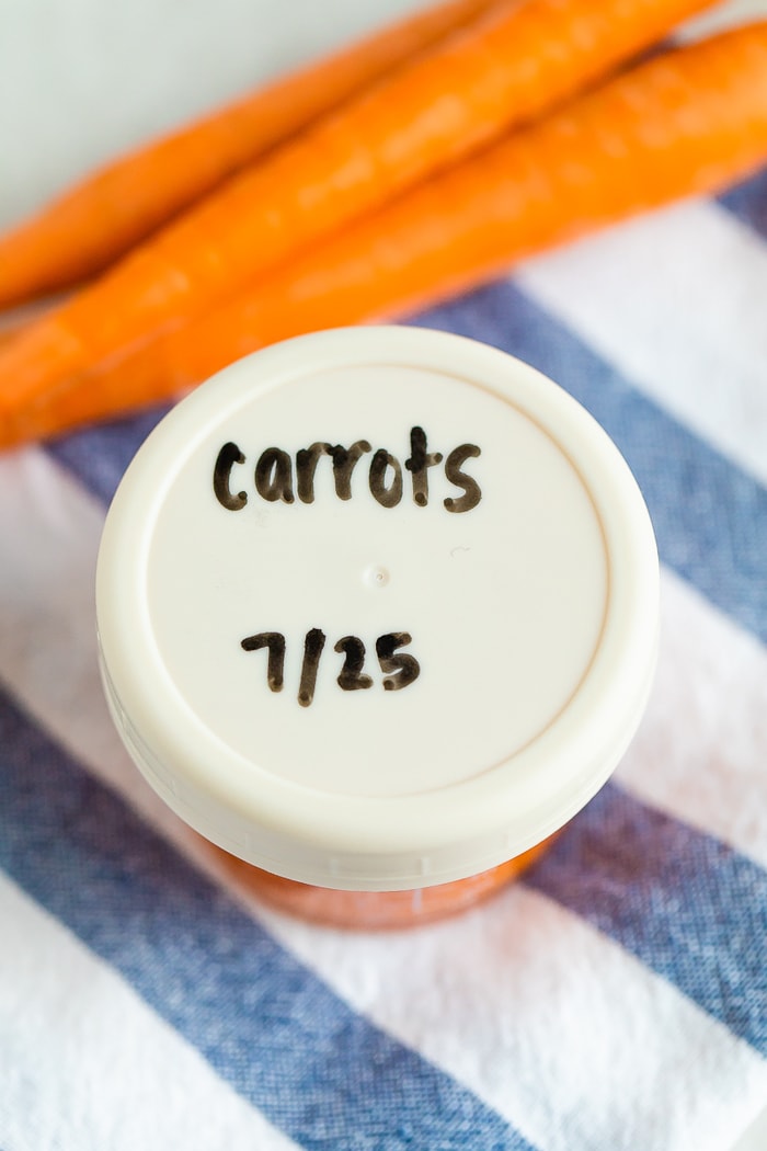 Carrot baby food in a glass storage jar with lid. Lid has "carrots 7/25" label.