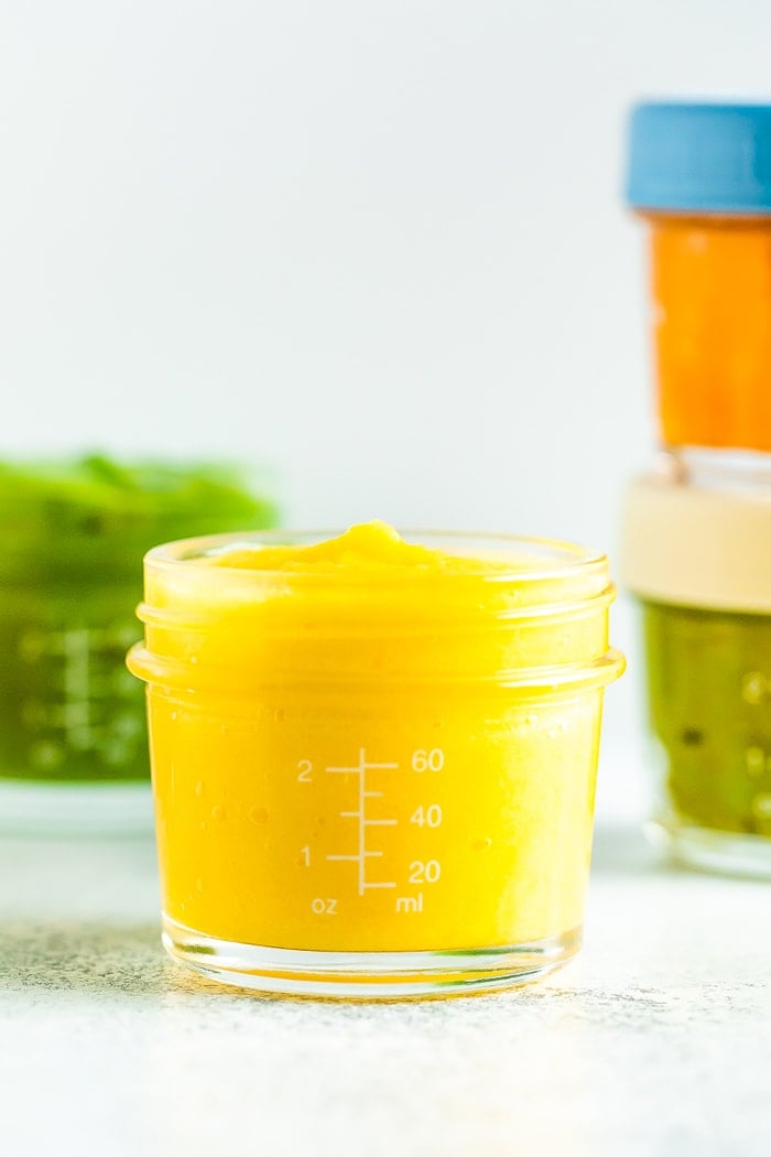 Pineapple mango baby food in a 4 oz baby food jar.