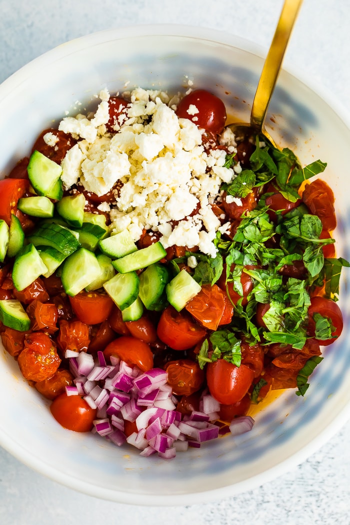 Mixing Bowl with feta, cucumbers, basil, red onion and tomatoes.