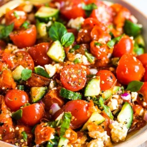 Close up photo of a tomato cucumber salad in a serving bowl.