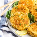 Plate with vegan crab cakes garnished with parsley and lemon slices.