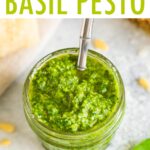 Overhead photo of a glass jar full of homemade pesto with a silver spoon in the jar.