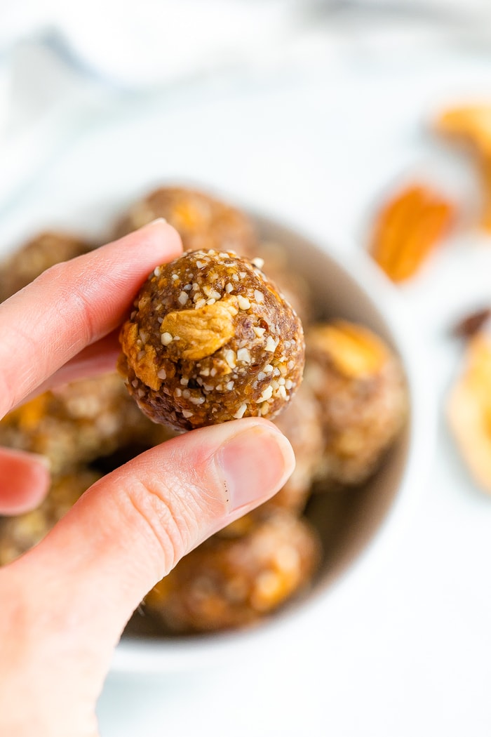 Hand holding an apple pie energy ball.