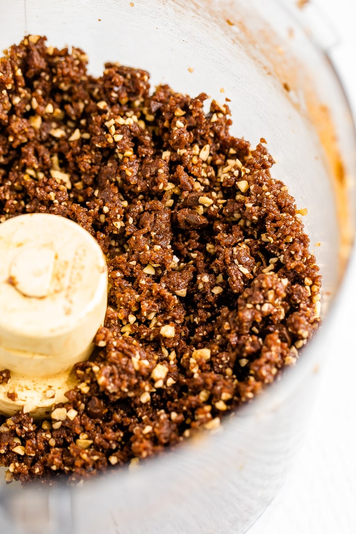 Food processor with pulsed dates and nuts for brownie energy balls.