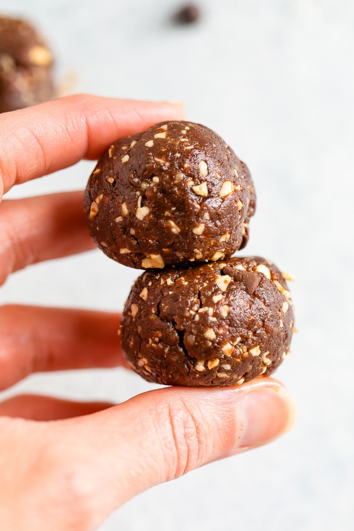 Hand holding two brownie energy balls.