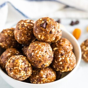 White bowl full of coconut chocolate chip energy balls.