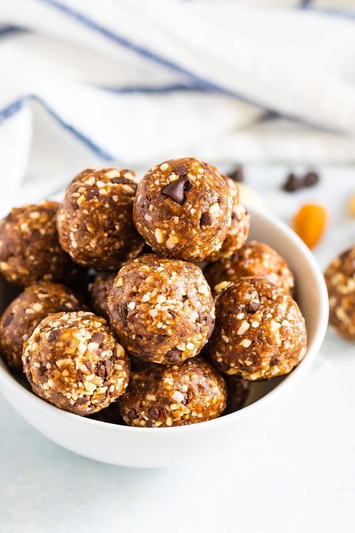 White bowl full of coconut chocolate chip energy balls.