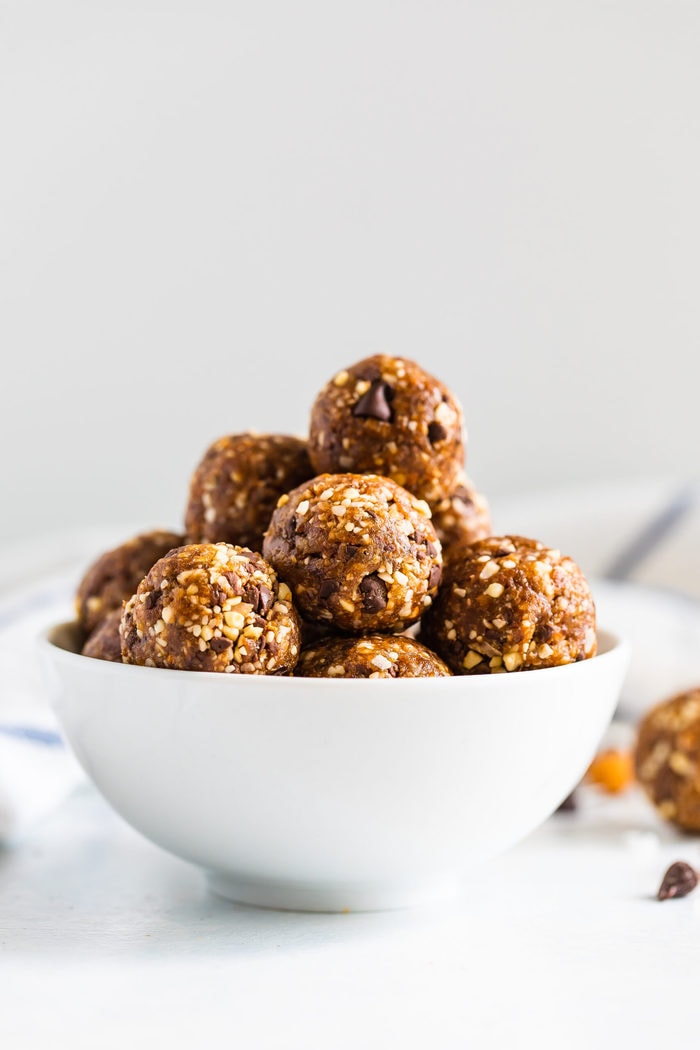 White bowl full of coconut chocolate chip energy balls.