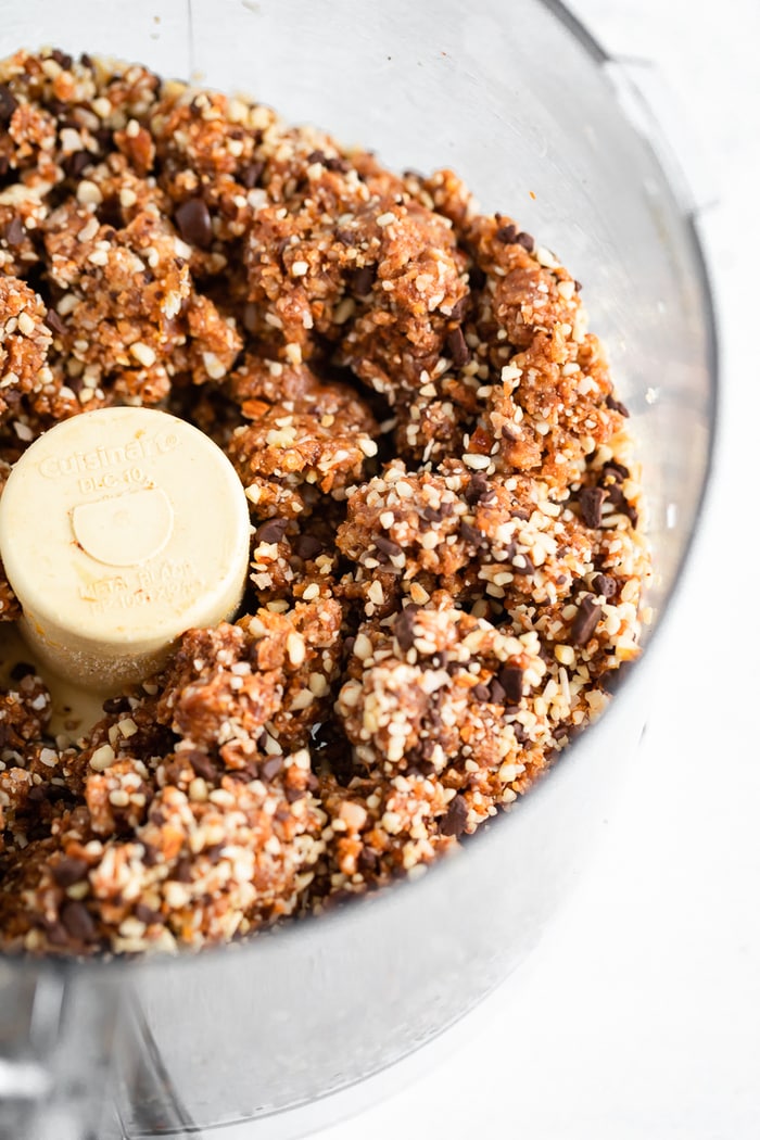 Food processor with coarsely pulsed nuts and ingredients for homemade Larabars.