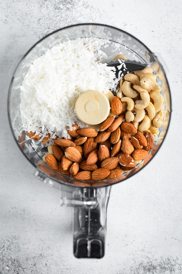 Food processor with coconut flakes, cashews and almonds.