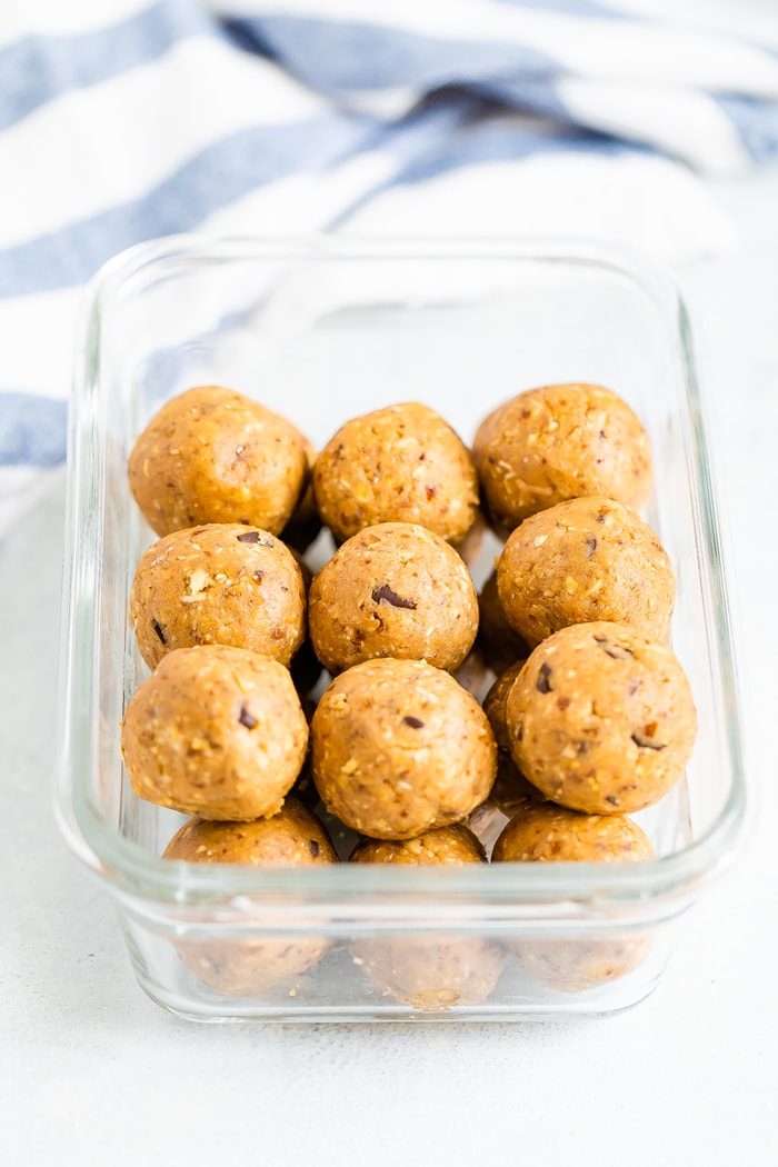 Glass food container full of cookie dough protein balls.