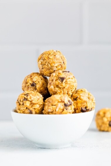 White bowl full of peanut butter chocolate chip energy balls.