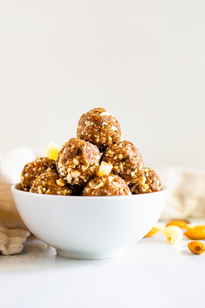 Straight on shot of a white bowl with gingerbread energy balls.