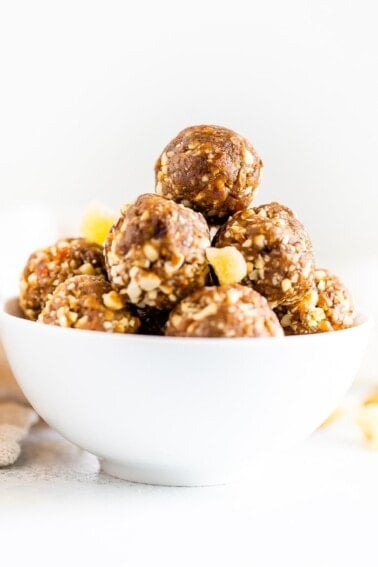 Straight on shot of a white bowl with gingerbread energy balls.