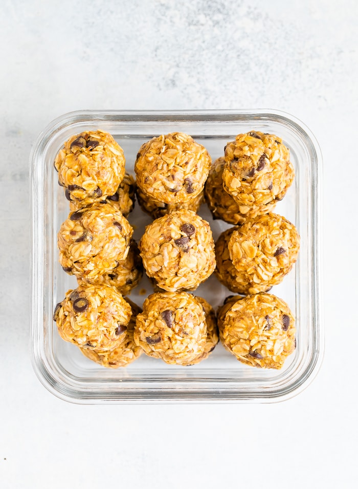 Square food storage container packed with peanut butter energy balls.