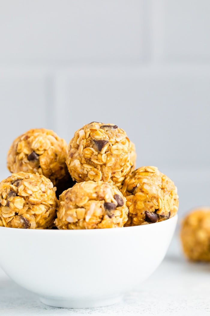 White bowl full of peanut butter chocolate chip energy balls.