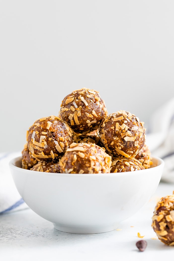 Straight on shot of samoa energy balls in a white bowl.