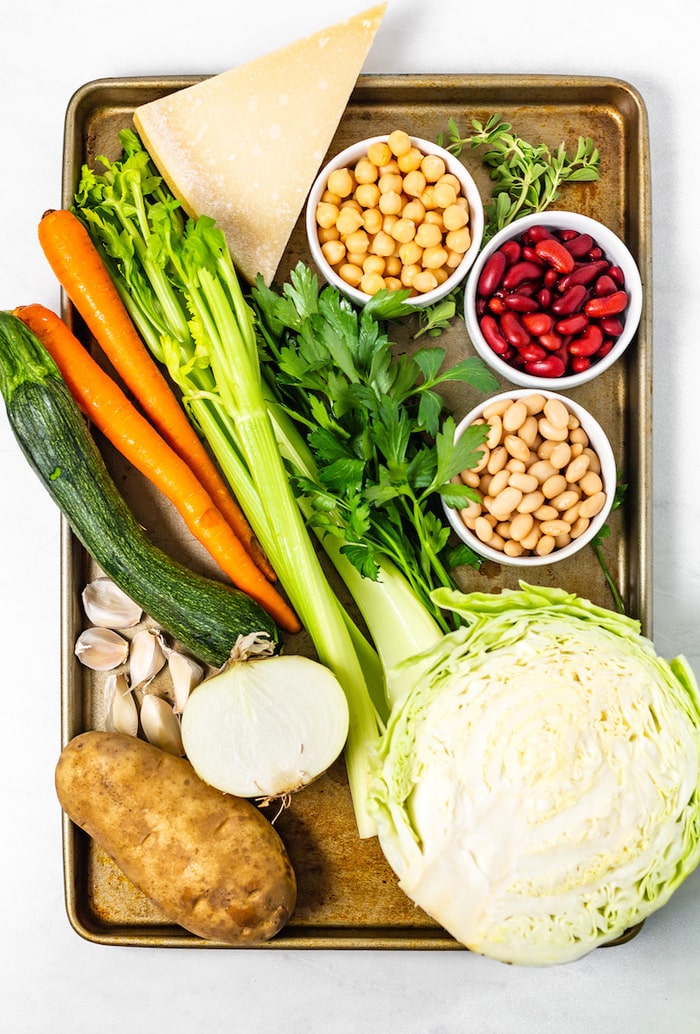 Ingredients for slow cooker minestrone soup on a baking sheet. 