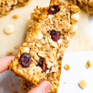 Hand holding one cranberry granola bar.