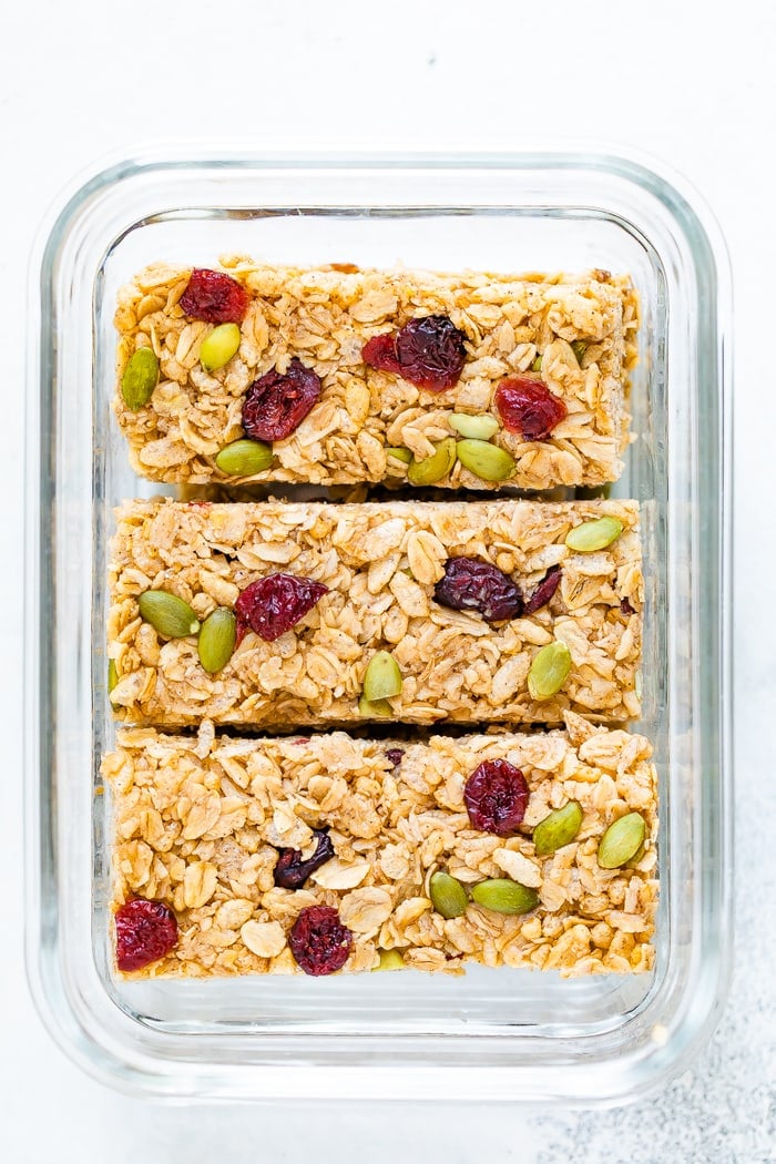 Three pumpkin spice granola bars in a glass food storage container.