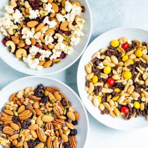 Three bowls of different trail mixes.