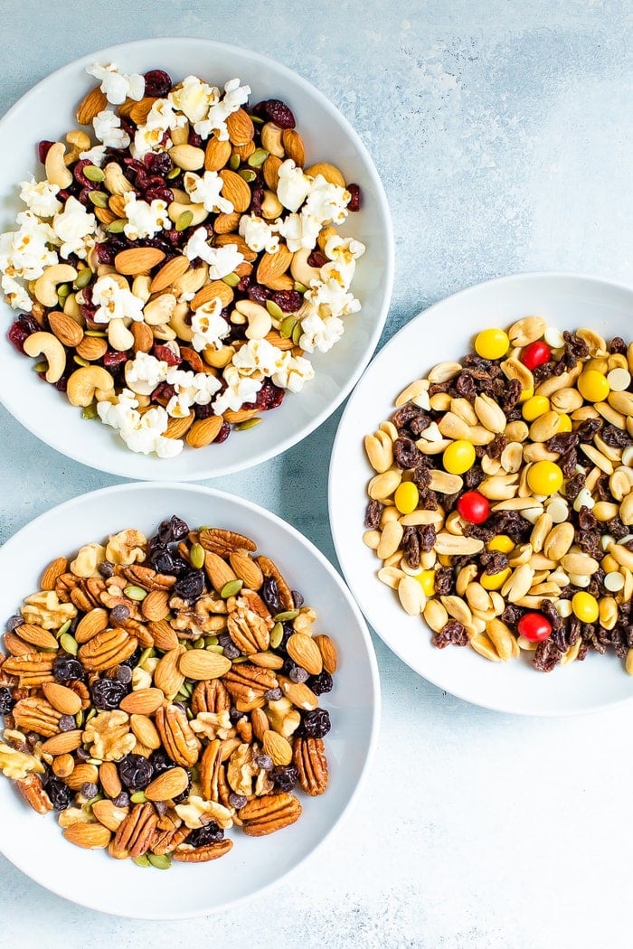 Three bowls of different trail mixes.