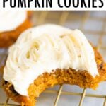 Pumpkin cookie topped with icing and a bite is taken out of it.