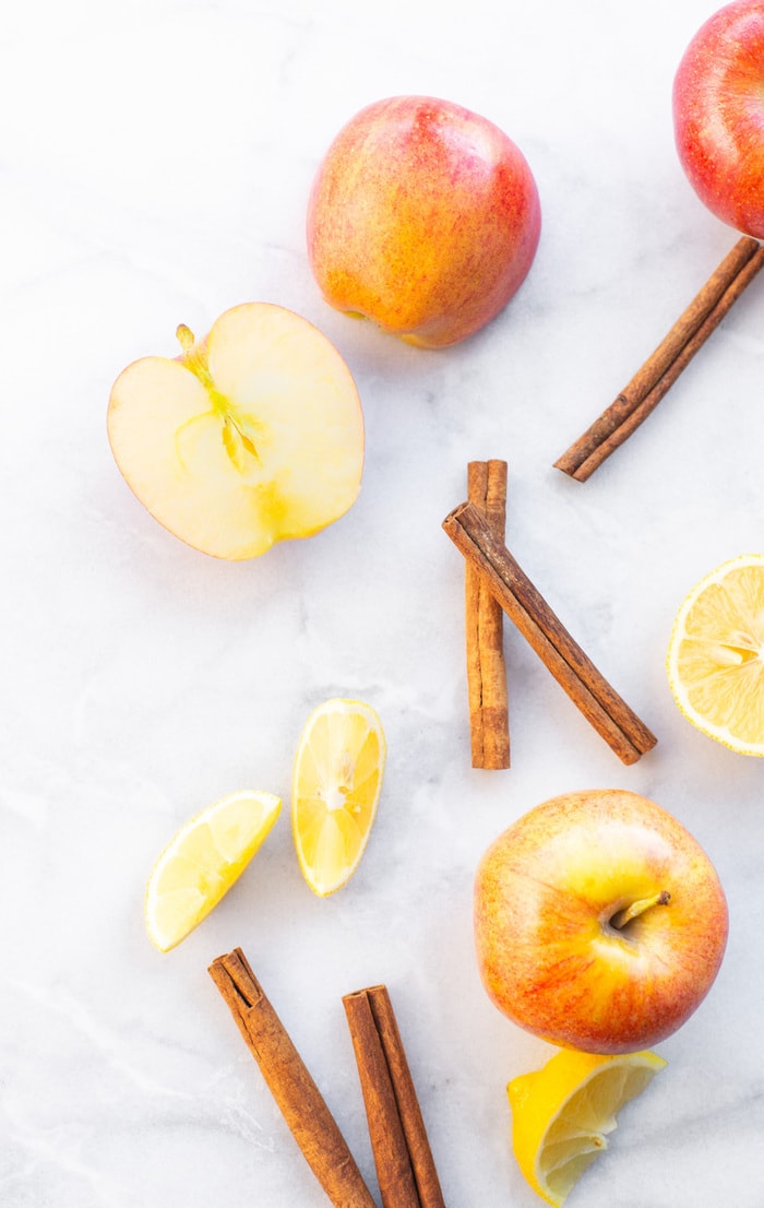 Ingredients to make homemade apple sauce: apples, cinnamon and lemon.