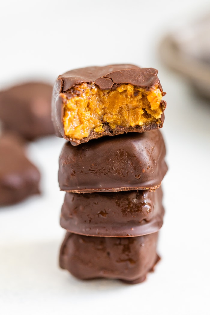 A stack of four homemade Butterfinger bites. Top one has a bite taken out of it.