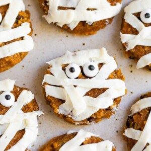 Cute mummy cookies frosted with stripes and decorated with two candy eyes.