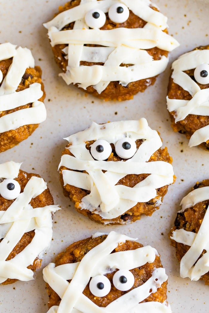 Cute mummy cookies frosted with stripes and decorated with two candy eyes.