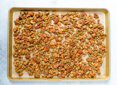 Spiced seeds, nuts and oats on a baking sheet.