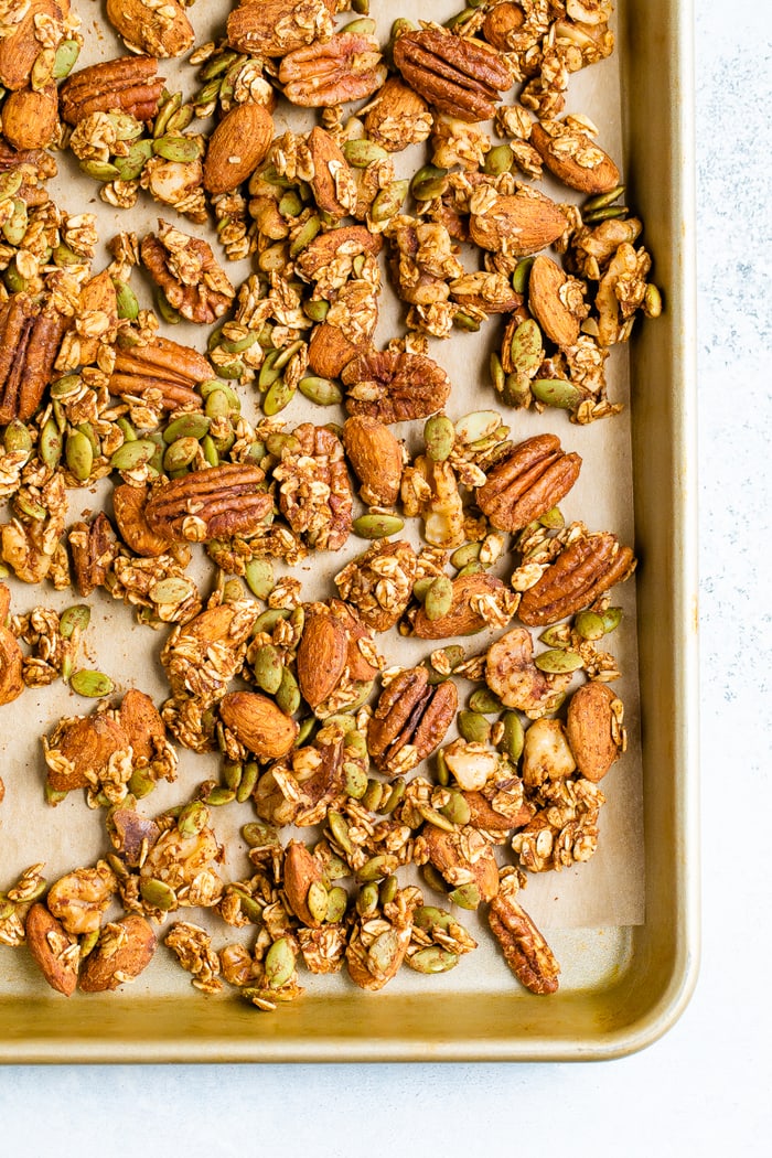 Spiced seeds, nuts and oats on a baking sheet.