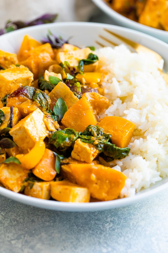 Bowl with half tofu pumpkin curry and half rice.