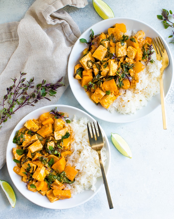 Two bowls with tofu pumpkin curry served with rice.