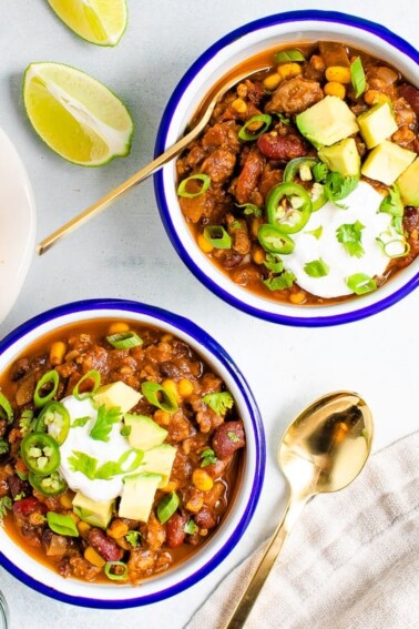 Bowls of turkey chili served with avocado, sou cream and cornbread.