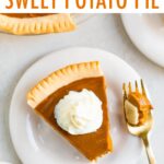 Slice of sweet potato pie topped with whipped cream. A bite is taken out of the pie.