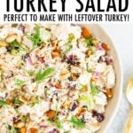 Bowl of creamy turkey salad with celery, cranberries and almonds.