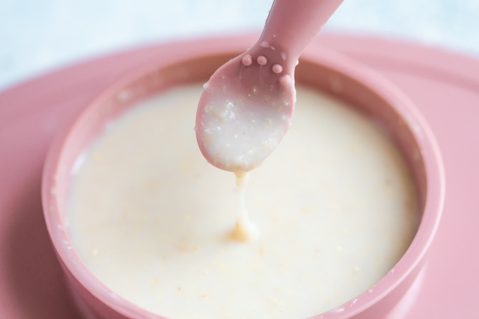 Thin baby oatmeal cereal for early (stage 1) eaters in a ezpz bowl with an ezpz spoon.