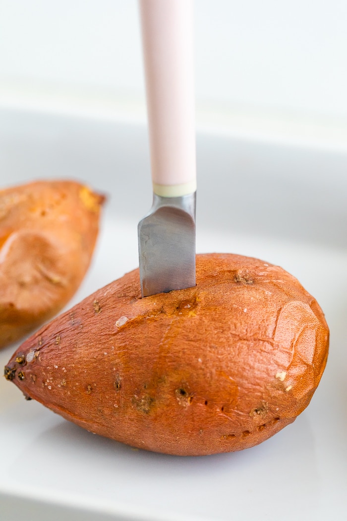 Knife cutting a baked sweet potato open