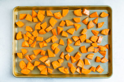 Sweet potato chunks on a sheet pan before being roasted.