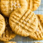 Peanut butter cookies sprinkled with sea salt on a cooling rack.